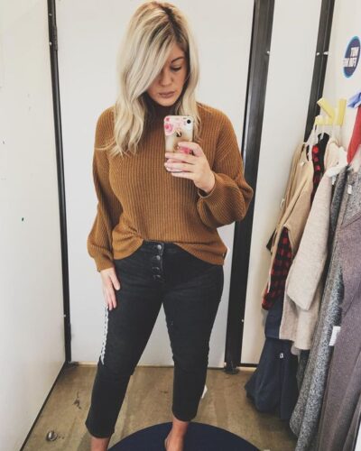 photo of midsize woman in black jeans and camel sweater top