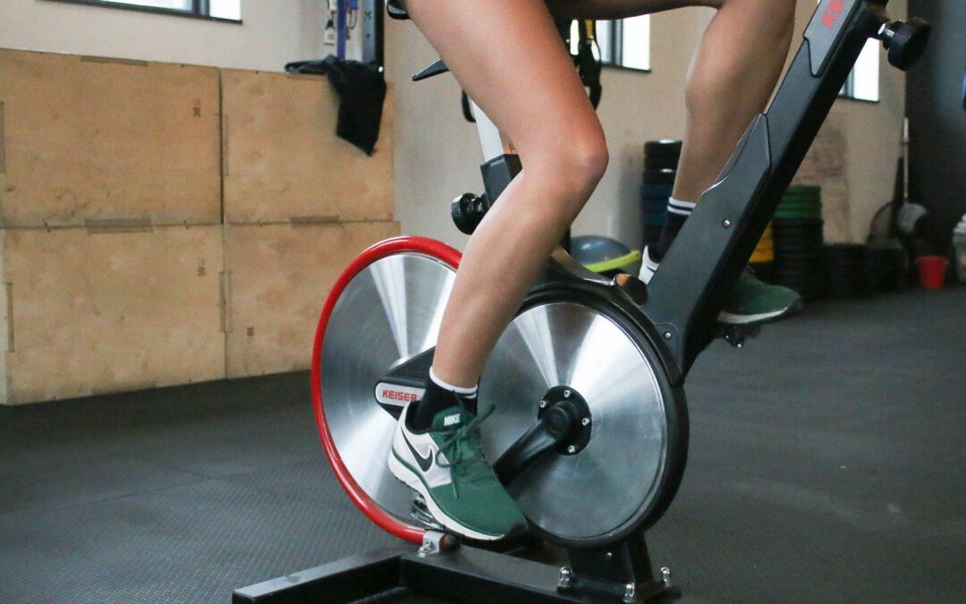 person exercising on cycling machine in gym
